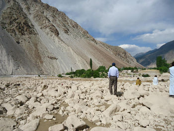 Rear view of man on mountain against sky