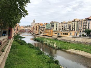 Canal amidst buildings against sky