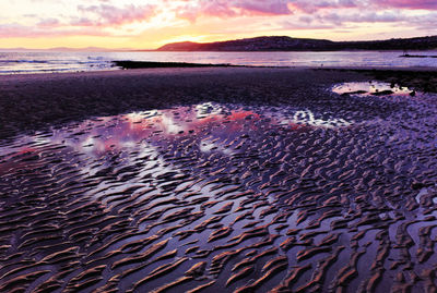 Scenic view of beach against sky during sunset