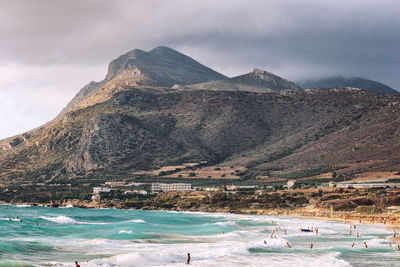 Scenic view of mountains against sky and sea splashing waves beach crete falasarna