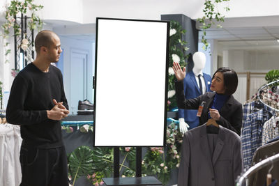 Rear view of businessman using digital tablet while standing in office