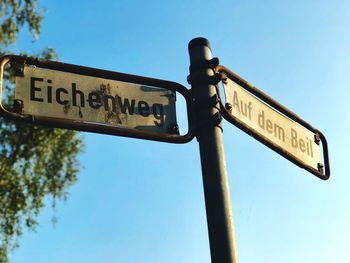 Low angle view of information sign against sky