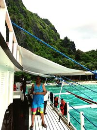 Portrait of man standing on boat against sky