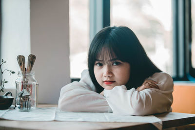 Portrait of girl sitting on table