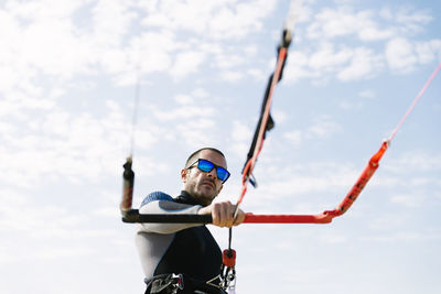 Low angle view of man holding umbrella against sky