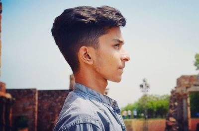 Side view of young man against clear sky