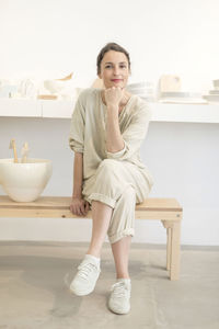 Full length portrait of owner sitting in store