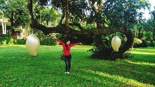 Full length of person standing by tree on field