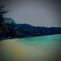 View of calm beach against clear sky