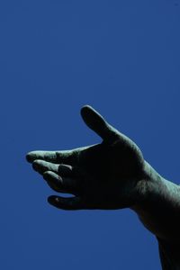 Low angle view of hand statue against clear blue sky