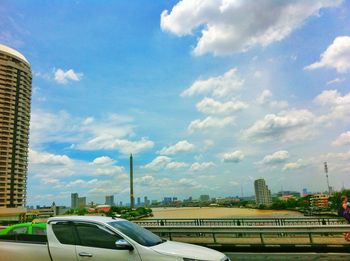 Cars on road in city against sky