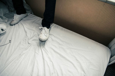 Low section of man relaxing on bed at home