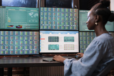 Young businesswoman analyzing graph on computer