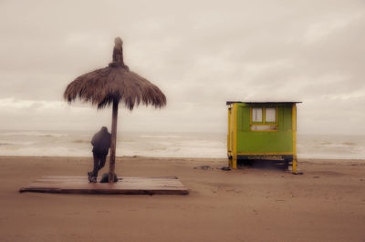 Man standing at beach against sky