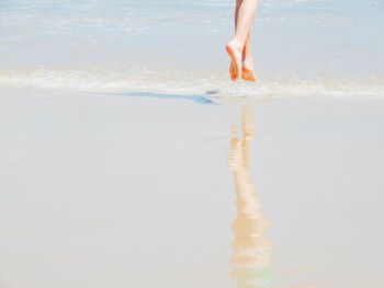 Low section of person standing on beach