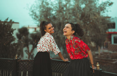 Happy woman standing against blurred background