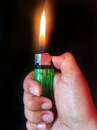 Cropped hand of person holding lit candle