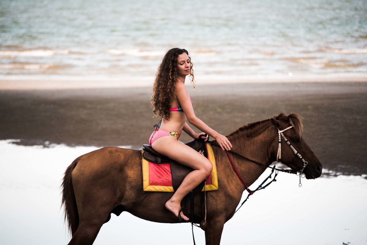 YOUNG WOMAN RIDING A HORSE