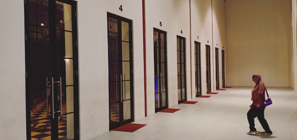 Rear view of woman walking in corridor of building