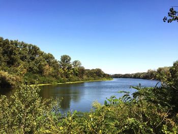 Scenic view of lake against clear blue sky