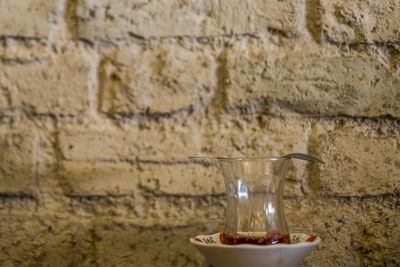 Close-up of drink on table against wall