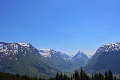 Scenic view of snowcapped mountains against clear blue sky