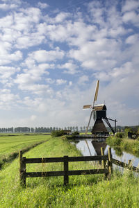 Traditional windmill on field against sky