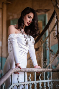 Thoughtful young woman standing by railing