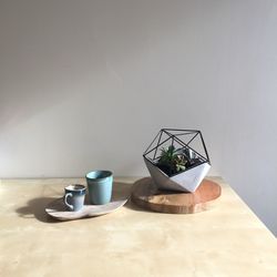 High angle view of coffee cup with decoration on wooden table against wall at home