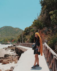 Woman standing on mountain against clear sky