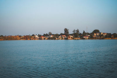 Scenic view of sea by buildings against clear sky