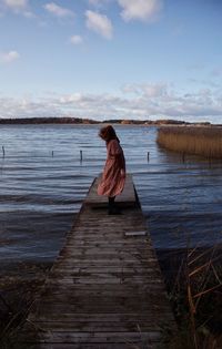 Lone girl standing ona a pier