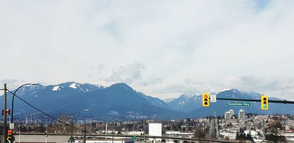 Road by mountains against sky