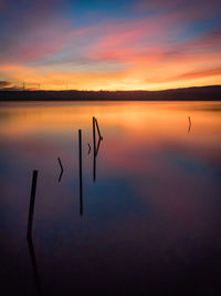 Scenic view of lake against sky at sunset