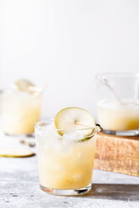 A short glass of non alcoholic refreshing pear soda water mocktail on concrete background