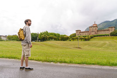 Portrait of man standing on road against sky