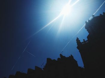 Low angle view of silhouette buildings against clear sky