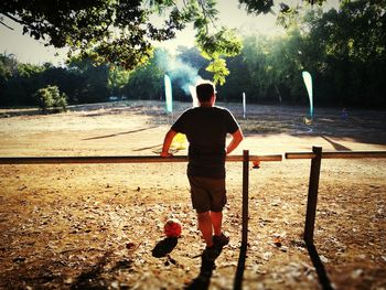 Rear view of man standing by lake