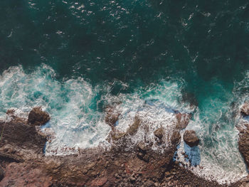 High angle view of people on rocks at sea