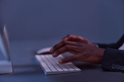 Cropped hands using laptop on table