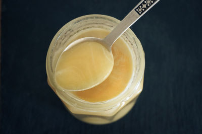 Yellow raw natural honey on silver spoon top view