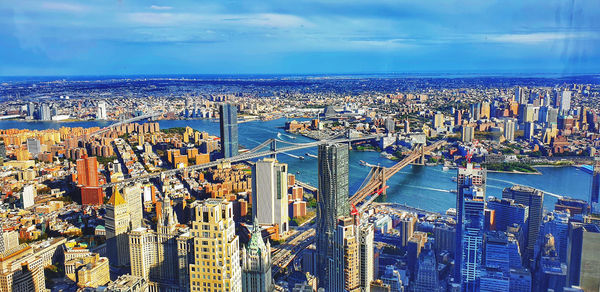 High angle view of modern buildings by sea against sky