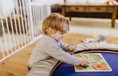 Side view of girl playing with toys at home