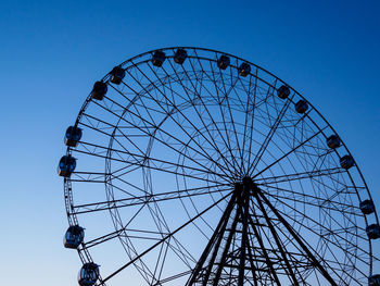 Low angle view of ferris wheel against blue sky