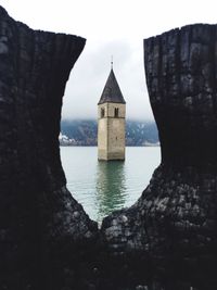 Castle by lake against sky