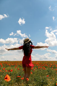 Full length of woman standing on field against sky