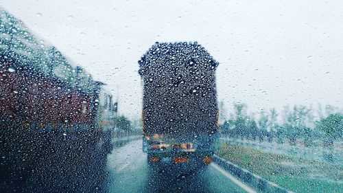 Trucks seen through wet window in rainy season