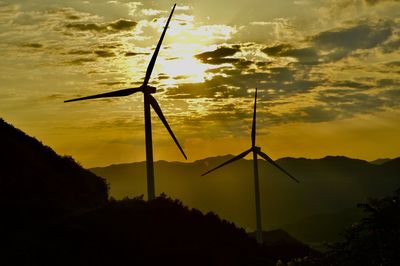 Low angle view of silhouette windturbine against sky during sunset