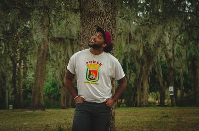 Full length of young man standing in forest