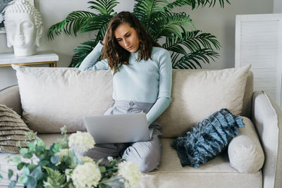 Beautiful woman on the couch working on a laptop.